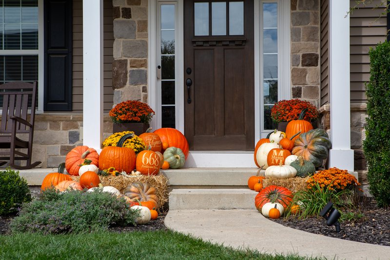 The Estate close on the front door, pumpkins and straw bales banked both sides, mums either side of the door