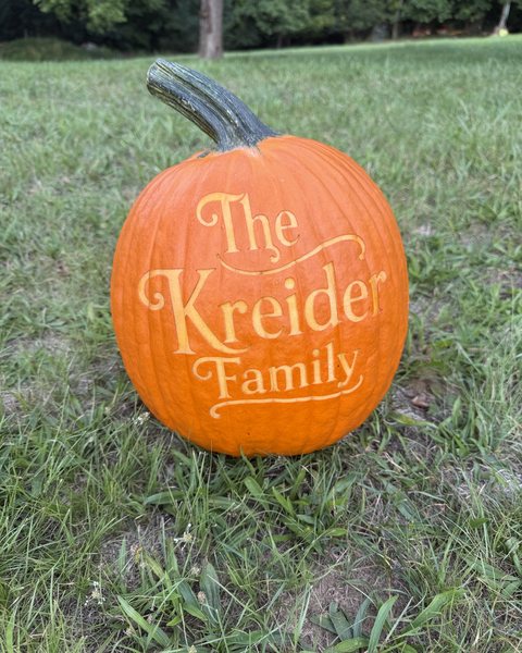The Kreider Family, engraved on a pumpkin sitting in the grass
