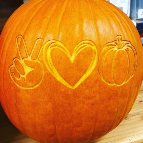 A pumpkin engraved with the peace, love and pumpkins ready-made design