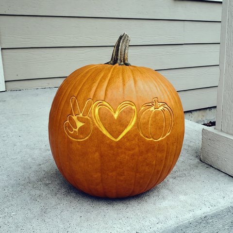 A pumpkin engraved with the peace, love and pumpkins design