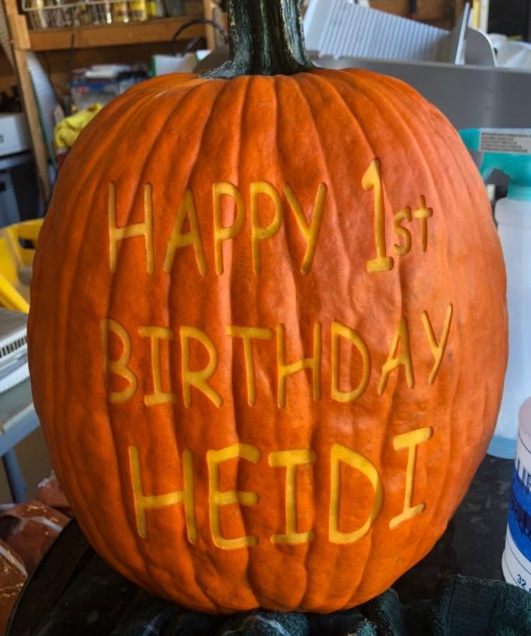 A pumpkin laser-engraved with Happy 1st Birthday Heidi
